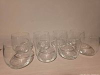 Eight clear stemless glasses arranged together