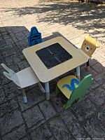 Full view of table with black center insert and three themed chairs