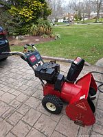 Left side view of Toro 824 snow blower showing auger housing, chute, engine and handle