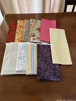 Ten folded cotton fabric pieces laid out