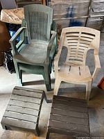 Stacked green and beige plastic patio chairs with two plastic foot stools