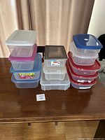 Stacked plastic containers on table showing quantity, lid colours, sizes