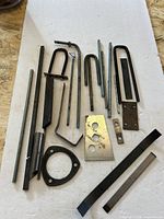 assorted rods, U-bolts, flat bar, plates on white surface
