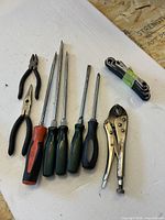 All tools laid out: 5 screwdrivers, 2 pliers, locking pliers, folding ratcheting wrenches