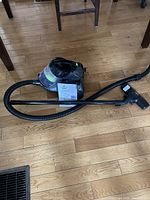 Vacuum body with attached hose, wand and instruction leaflet