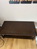 Top view of dark brown rectangular coffee table with lower shelf visible