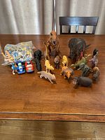 Full lot with dinosaur & animal figures, toy cars, bagged puzzle pieces on table