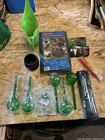 All items laid out including yard bag packaging, irrigation kit roll, watering can, spikes, pot, watering globes