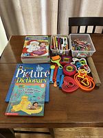 Books, art supplies and play-dough cutters displayed on table
