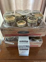 Two shrink-wrapped trays containing 24 Golden Harvest 500 ml mason jars with gold lids