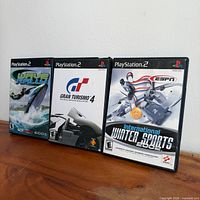 Three PlayStation 2 game cases standing side-by-side showing front cover art