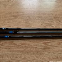 Three graphite shafts laid side by side showing full graphics