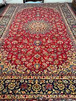 Full view of rug showing red field and navy border