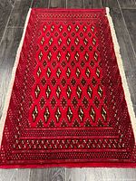 Full view of red Turkman rug showing entire design and edges