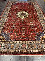 Full view of handmade Persian rug laid flat showing overall pattern and borders