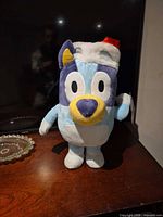 Front view of Bluey plush with Santa hat