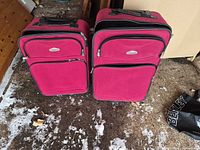 Front view of both pink Cambridge by Travelway suitcases standing side by side