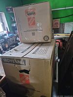 Stacked Home Depot moving boxes containing the shoe bins