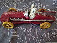 Left side profile showing red body, yellow wheels, Bibendum driver