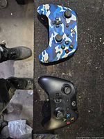 Top view showing blue camo PowerA controller and black Microsoft controller