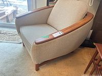 Full view of upholstered armchair showing fabric, teak arms and legs