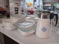 Group shot of percolator, three square casseroles with lids, two oval dishes