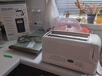 Countertop view: Cuisinart toaster, Salton warming tray, food cover