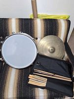Overall view of snare drum, cymbal, stick pouch with sticks