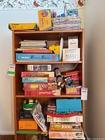 Full view of four-shelf bookcase loaded with crayons, books, board games, puzzles and toys