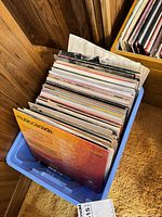 Blue plastic tote filled with numerous vinyl LPs showing spines and Music Canada cover
