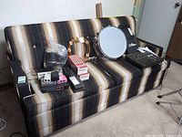 Front view of striped sofa bed with contents on top (not included)