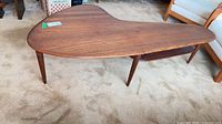 Full view of boomerang teak coffee table on carpet