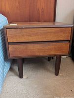 Front view of nightstand showing two drawers and legs