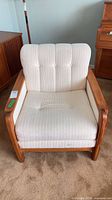 Front view of teak armchair showing full frame and upholstery