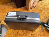 Closed black plastic carrying case with handle