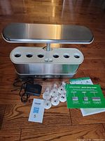 Full AeroGarden unit with light arm lowered, pods, AC adapter, setup guide visible