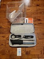 Circulator in open case with clamp, power cord, manual, Cambro container and cut lid visible