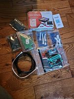 Group shot showing Velleman oscilloscope kit tin, programmer, project kits, USB cable