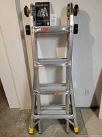 Folded ladder standing upright with manual on top