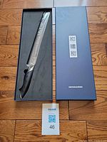 Knife in open presentation box with branded lid