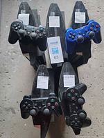 Top view of five PS3 consoles each with a controller on top, labels visible