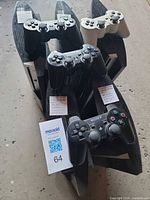 Stacked view of five PS3 consoles each with a controller on top