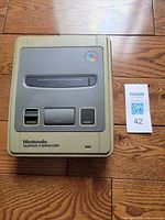 Top view of Nintendo Super Famicom console beside lot tag