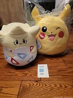 Pikachu and Togepi Squishmallows side by side on floor with lot card