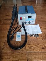 Front view of 850D+ rework station with hose, handle, power cord, four nozzles and manual