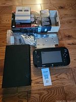 SNES Classic mini console, retail box, Wii U console, GamePad, metal plate, bag of screws visible together