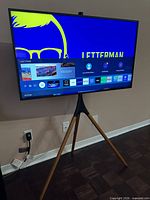 TV powered on displaying smart hub interface on tripod stand
