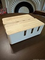 Two white cable boxes with wood lids shown side by side angled view