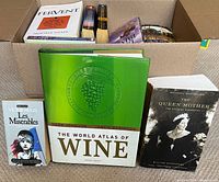 Front view showing box with multiple books, including Les Misérables paperback, World Atlas of Wine hardcover, The Queen Mother paperback, Fervent paperback, and additional titles