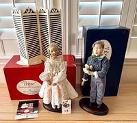 Front view of both Bing & Grondahl porcelain dolls with boxes and stands visible